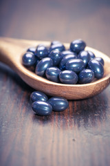 Cod liver oil omega 3 gel capsules isolated on wooden background