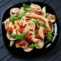 Glass plate with traditional italian pasta alla Norma, close-up