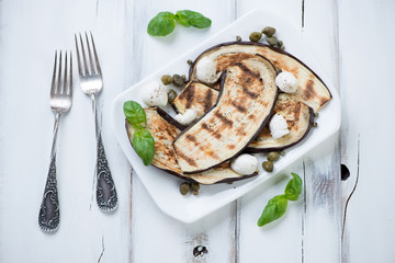 Grilled aubergine slices with mozzarella cheese and capers