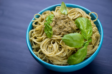 Close-up of spaghetti with basil pesto in a glass bowl