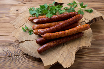 Smoked sausages with parsley over rustic wooden background