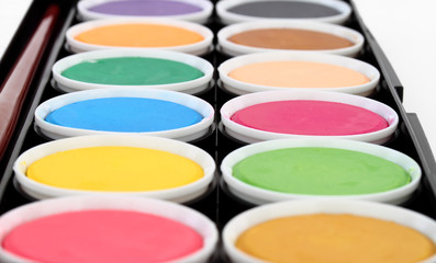 paints of different colors and slim paintbrush (brush)
