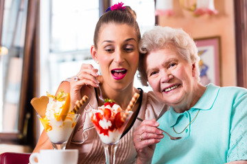 Oma und Enkelin essen Eisbecher im Cafe