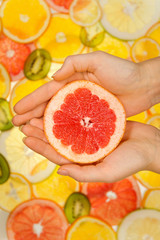 Fresh grapefruit slice in woman hands