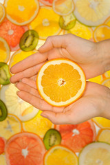 Fresh orange slice in woman hands