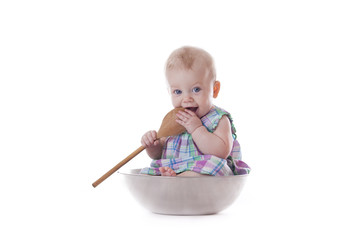 baby girl holding wooden spoons