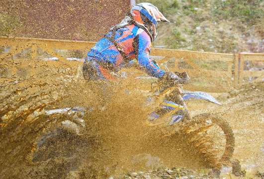 Motocross racer on wet and muddy terrain