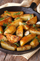 Baked potatoes in a frying pan close-up vertical