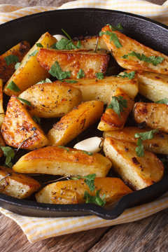Baked potatoes with parsley and garlic in a frying pan vertical