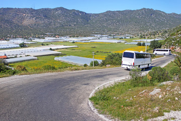 Greenhouse and touristic buses near village in Turkey
