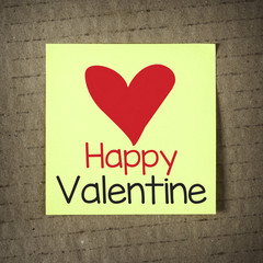 Blank yellow note with Happy Valentine on grunge background