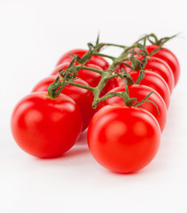 Juicy organic Cherry tomatoes with green leaf isolated over whit