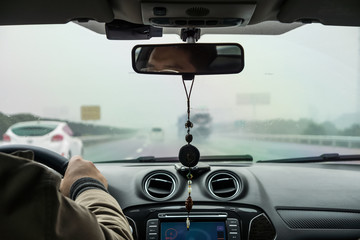 Driver is driving a car in rainy day