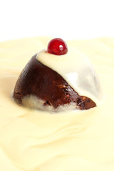 Pudding with custard and cherries on a white background.