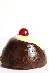 Pudding with custard and cherries on a white background.