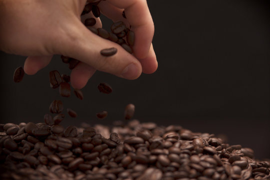 Hand Grabbing Coffee Beans.