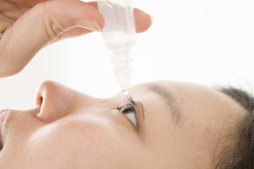Obraz premium Woman pointing to eye drops