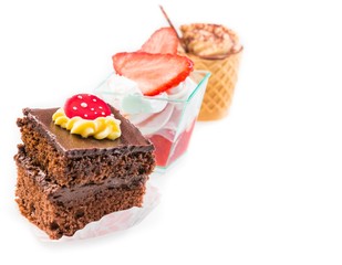 chocolate cake in front of little coffee and strawberry cakes