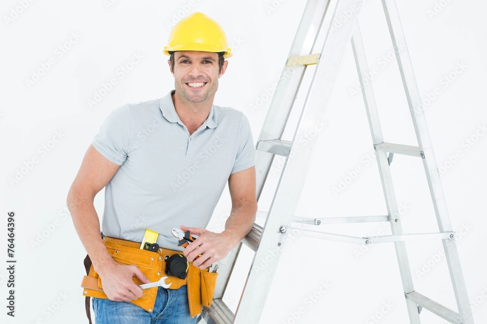 Poster worker holding tools while leaning on step ladder