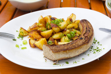 Frisch gebratene Bratwurst mit Röstkartoffeln