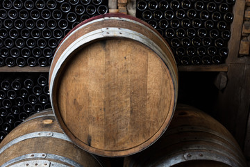Oak barrels with wine bottles