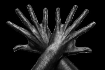 Strong male hands in black paint on black background 