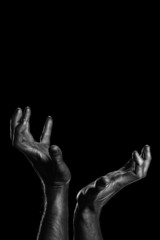 Strong male hands in black paint on black background 