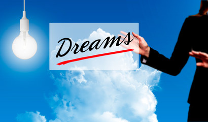 Business woman holding dreams sign - business concept