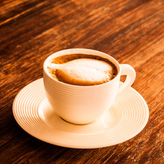 A cup of hot latte  coffee  on a wooden table.
