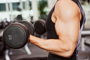 Fototapeta na wymiar Gym: Muscular Man Works Out With Dumbells In Gym