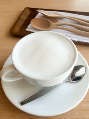 Fototapeta na wymiar Hot milk cup with spoon and fork on table