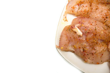 Fillet of fresh raw chicken with seasoning on a plate. Photo.