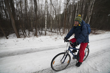 View of a cyclist in winter forest