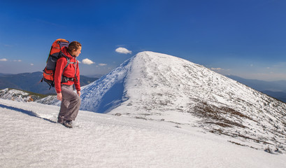 Hiker girl with backpack  in a high mountains