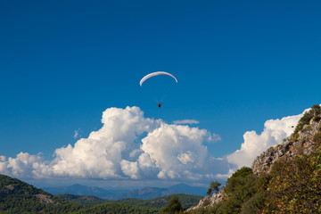 Paraglider flying over sky in summer day