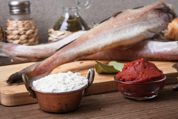 Fresh fish, vegetables, flour, tomatoe paste and spices on a woo