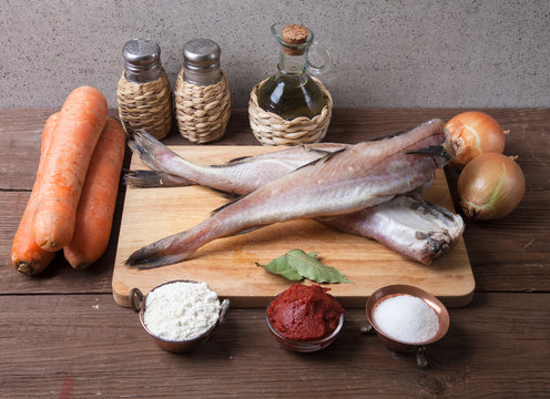 Still life with fish, vegetables and spices on a wooden board