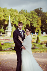 Naklejka premium Bride and groom against fountain
