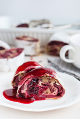 Cherry and walnut strudel on a white table. Closeup