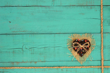 Burlap and fabric heart on teal blue wood background