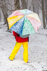 Man with colored umbrella under a snowfall