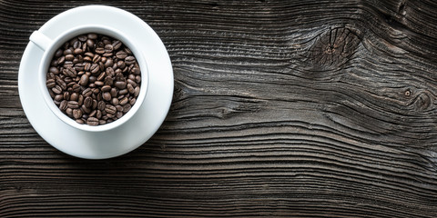 Tasse mit Kaffebohnen auf altem Brett von oben