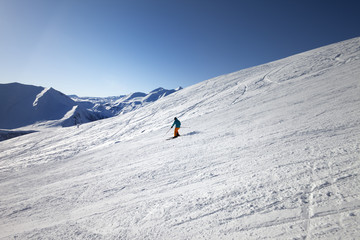 Fototapeta na wymiar Skier on slope in sun day