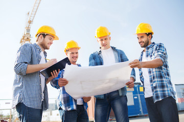 group of builders with tablet pc and blueprint