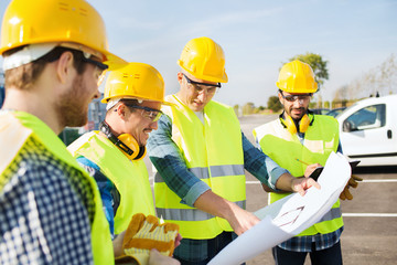 group of builders with tablet pc and blueprint