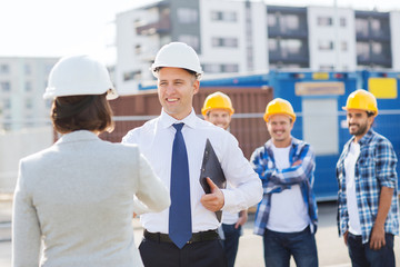 group of smiling builders in hardhats outdoors