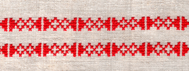 red ornament stitched on linen background