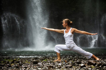 woman meditating doing yoga between waterfalls