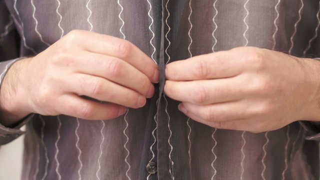 Male Buttoning Up His Shirt