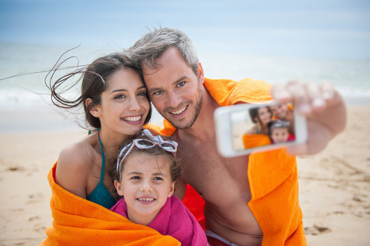 A young couple and their daughter taking a selfie